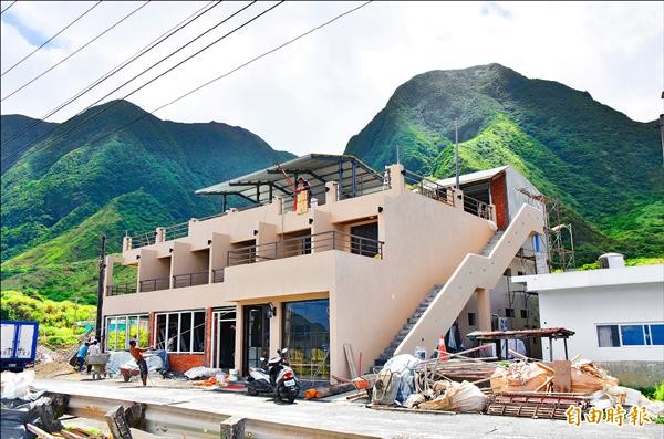 統一超商擬在蘭嶼開元港附近開店，引發文化爭議成為新興觀光景點，昨天上午客輪載來數百名遊客，很多人一下船就到小七工地觀光。（記者張存薇攝）