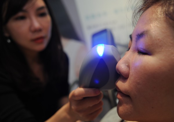 新光醫院皮膚科主任唐豪悅（左）親自示範「醫洗臉處方系統」，利用負壓技術吸出毛孔內髒污及粉刺，為皮膚徹底清潔。（記者劉信德攝）