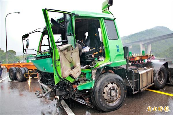 曳引車大雨打滑失控，橫亙在路中間，造成交通打結。（記者吳政峰攝）