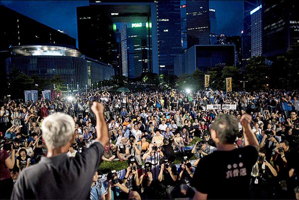 中國人大常委會八月卅一日通過香港特首「假普選」案。香港泛民主派當晚集會抗議，佔中行動發起人戴耀廷（右）與朱耀明（左）呼籲港人做自己的主人。戴耀廷近來受訪時暗喻「佔中」將於十月一日再次啟動。（資料照，法新社）