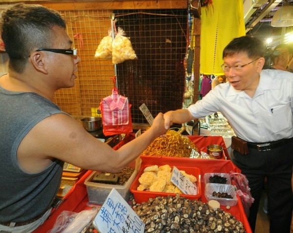 台北市長參選人柯文哲今日上午前往成功市場掃街拜票，一一跟攤商及民眾握手。（記者王敏為攝）