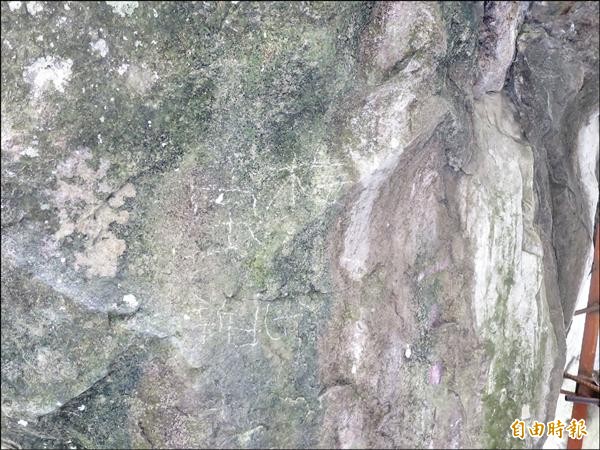 信義鄉琉璃光之橋園區巨石遭人刻上文字，石頭上還能辨認出「寶梅、新北」字樣。（記者劉濱銓攝）