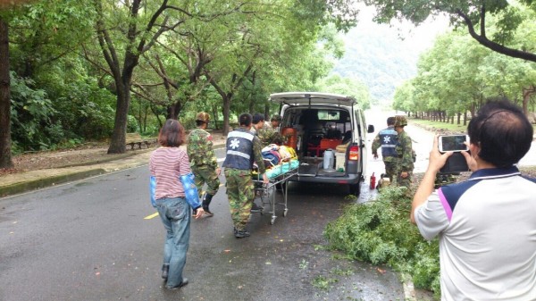 一名吳姓工作修剪樹木掉落路面受傷，軍方緊急派救護車將他送醫。（圖由軍方提供）