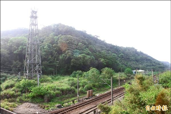 山線鐵路左側山林為三義外環道用地，惟興建案牽涉石虎棲地，引發保育人士關切，目前環評仍未過關。（記者張勳騰攝）