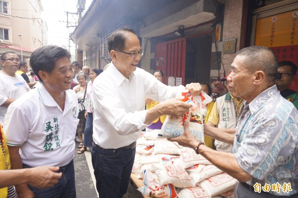 新北市長參選人游錫堃（中）今偕同議員吳琪銘（左）協助廟方發米，現場湧入逾600名民眾排隊領取。（記者張安蕎攝）