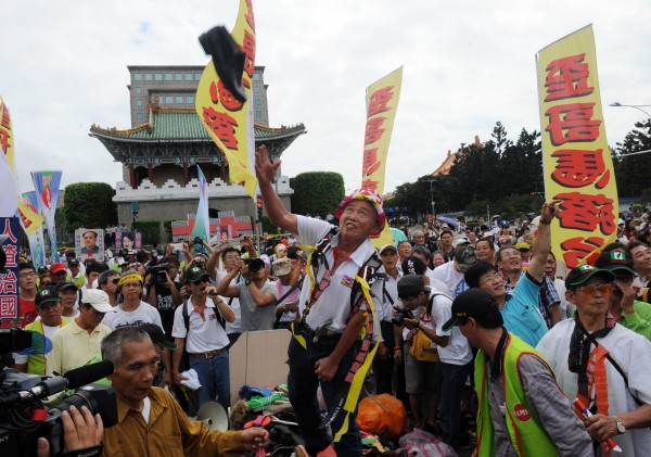 「908台灣國」總會長王獻極與成員賴芳徵朝馬英九丟擲運動鞋和資料袋被起訴，高等法院今仍判兩人無罪，全案定讞。圖為前年10月10日，908台灣國在王獻極（中）帶領下，帶著棺木到立院大門口抗議，隨後抬棺遊行至景福門前「埋鞋葬馬」，並朝總統府丟鞋。（資料照，記者羅沛德攝）