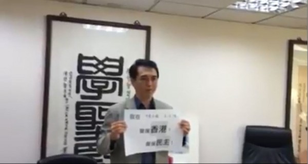 陳學聖手拿「我在中華民國立法院聲援香港！聲援民主！」表示，看到香港這樣的民主轉變過程，「我們給予很高的聲援」。（圖擷取自臉書）

