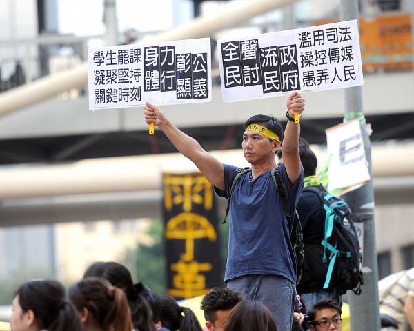 民眾在政府總部前舉標語表達訴求。（特派記者方賓照攝）