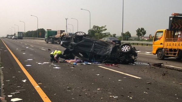 黑色自小客車扭曲變形，一名駕駛死亡，血流滿地。（記者謝銀仲攝）