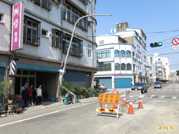 苗栗縣頭份鎮銀和路施工路段，一路燈電桿遭轉彎的砂石車攔腰撞歪。（記者鄭鴻達攝）