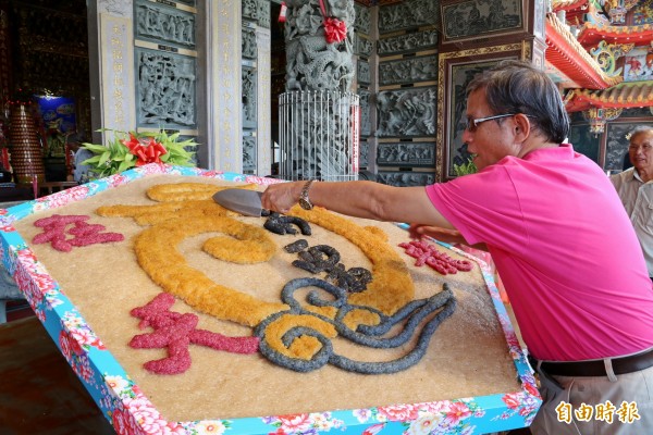 奉獻給神農大帝的「飛龍在天」風箏粄，在三獻禮後，由苗栗市長邱炳坤「分粄」，供現場民眾嘗鮮。（記者張勳騰攝）