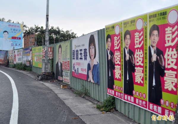 年底選戰逼近，市區街頭掛滿參選人的競選看板和旗幟，熱鬧且壯觀。（記者李容萍攝）