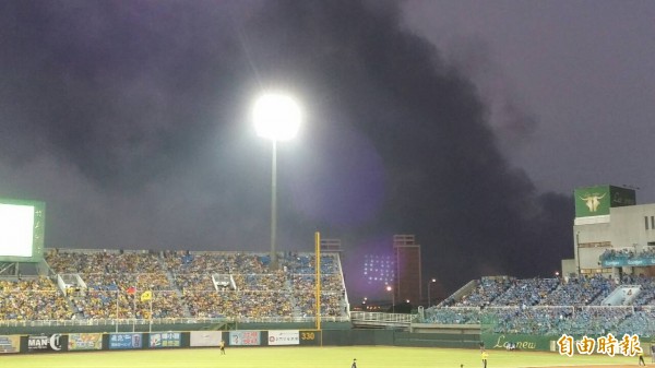 青埔棒球場上演總冠軍戰，附近工廠發生火警，從看台可見大量濃煙。（記者林子翔攝）