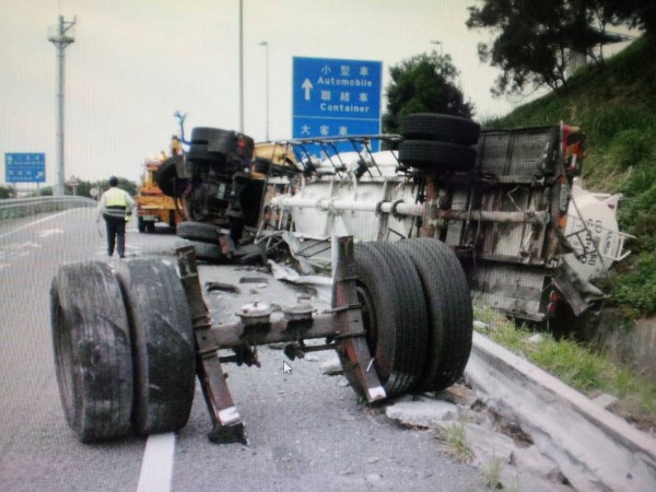 化學槽車撞破護欄在服務區匝道前翻落匝道邊坡。（記者彭健禮翻攝）