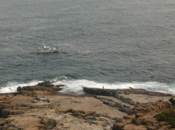 海巡署艦艇在海上廣播，要求釣客勿在危險海域逗留。（記者吳政峰翻攝）