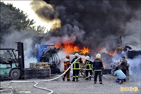 資源回收場火警，現場火勢猛烈，濃煙遮日，並傳出陣陣爆炸聲響。（記者李容萍攝）