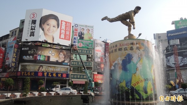 由律師嚴庚辰出資的「投給陳以真就是支持馬英九」看板，又掛上噴水圓環另一處大樓，毗鄰陳以真的競選看板。（記者丁偉杰攝）