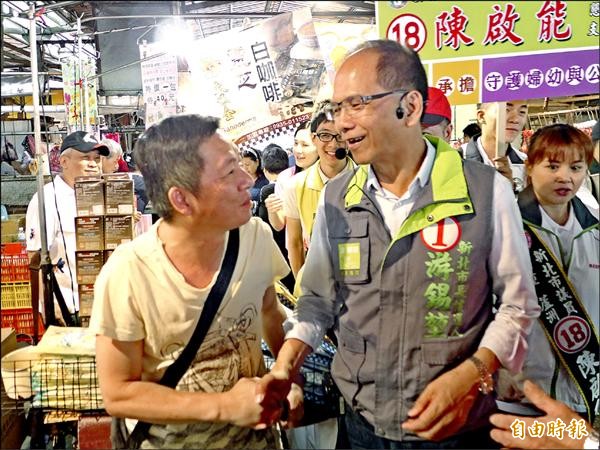 民進黨新北市長候選人游錫堃到三重區力行市場拜票，與攤商握手爭取支持。（記者李雅雯攝）