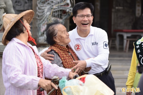 民進黨台中市長候選人林佳龍在大肚山車隊掃街，與民眾親切互動。（記者俞泊霖攝）