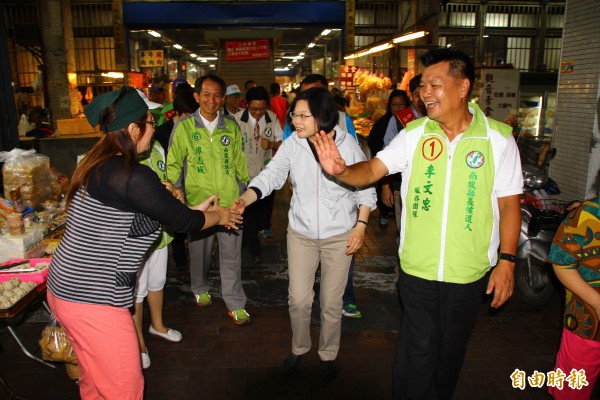 民進黨主席蔡英文（中）陪同南投縣長候選人李文忠（右）到埔里市場拜票，攤商熱情握手相迎。（記者佟振國攝）