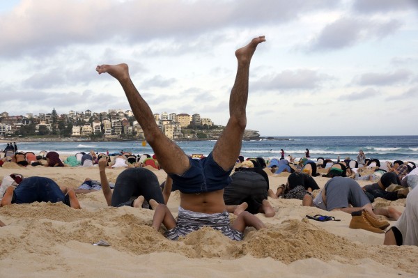 G20鋒會在即，澳洲示威民眾將頭埋入沙中，抗議政府不重視氣候變遷問題。 （法新社）