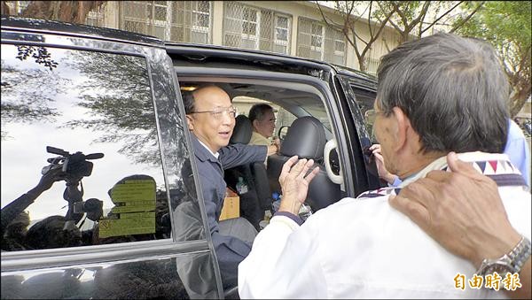 胡志強（左）上車離去時，遭林姓男子（右）嗆聲「我支持林佳龍」。（記者俞泊霖攝）