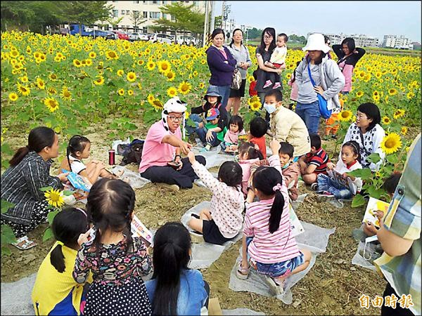 志工在花海中說故事，讓孩子感受休閒氛圍。（記者林孟婷攝）