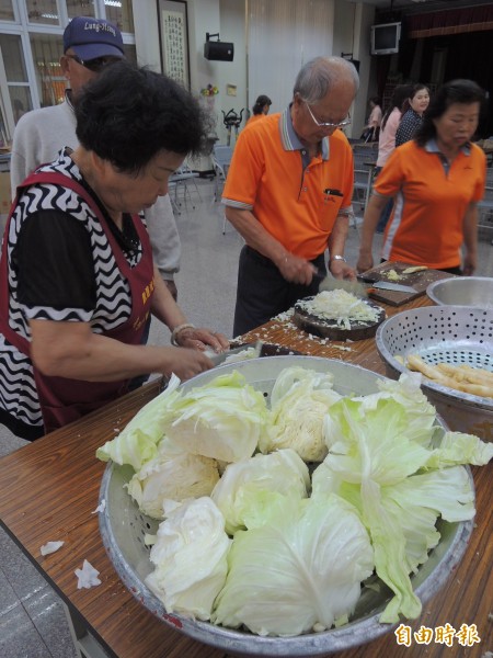 志工們俐落地切著高麗菜，要包出大顆美味的愛心水餃。（記者林孟婷攝）