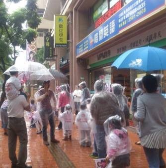 網友指控林富子讓小朋友在雨中拿文宣拜票。（圖擷取自「靠北北大」臉書）