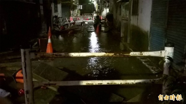 基隆晚間驟雨，淹水溢出路面。（記者林欣漢攝）