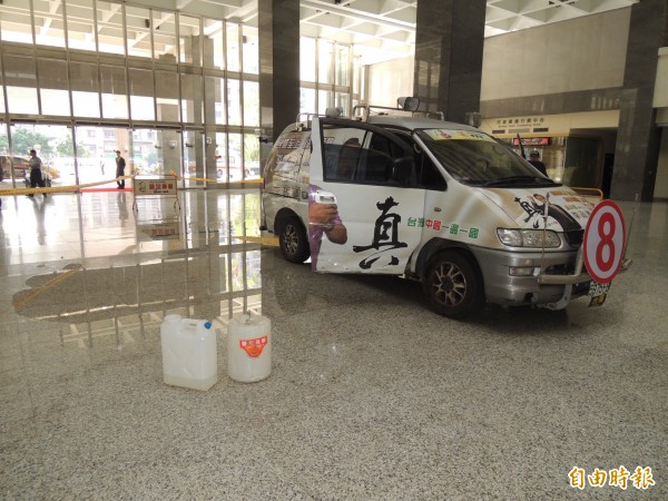 李政憲開宣傳車衝進高市府，2桶柴油灑滿中庭大廳。（記者洪定宏攝）