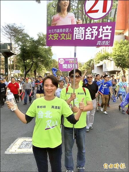 大安文山區議員候選人簡舒培（前）首次參選，先生吳振嘉（後）擔任專屬的舉牌手。	（記者邱紹雯攝）