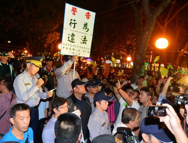 游錫堃競選總部今晚在板橋火車站站前廣場舉辦新北幸福音樂會，因場地未獲新北市政府核准，新北警察局板橋分局今晚舉牌警告現場為非法集會，要求解散。（記者王藝菘攝）