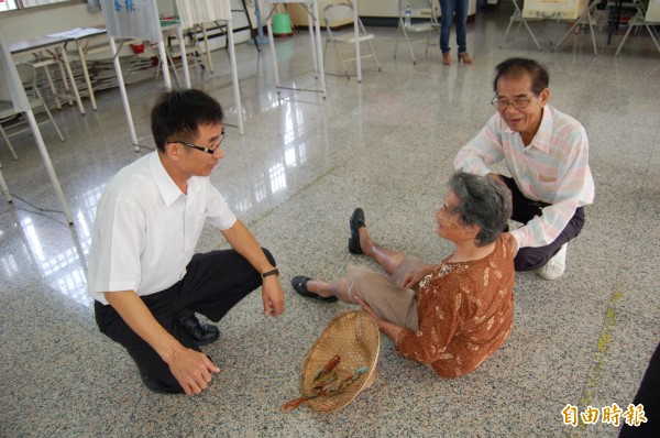 82歲李姓阿嬤（中）要投票時，和另位里民碰撞而跌傷，視察投票所的區長李添財（左）和里長張輝明（右）趕緊查看阿嬤傷勢。（記者楊金城攝）