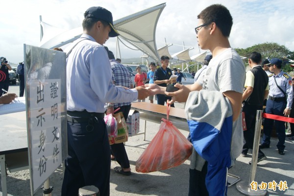 海巡人員今天下午隊從綠島搭船回富岡漁港的旅客逐一比對身分。（記者王秀亭攝）