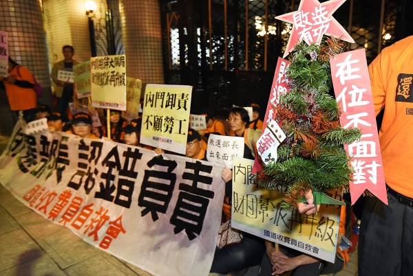 國道收費員自救會3日前往交通部長葉匡時住家外圍堵葉匡時，成員們呼喊「敗選部長，出來面對」口號要求葉匡時認錯負責，並準備一小棵寫著「敗選有功」的耶誕樹打算送給他。（記者廖振輝攝）