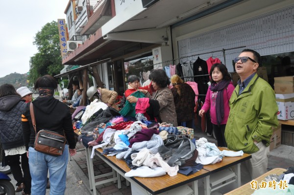 民進黨前立委賴坤成（右）上午在台東市南京路義賣二手服飾，吸引婆婆媽媽們搶購。（記者黃明堂攝）