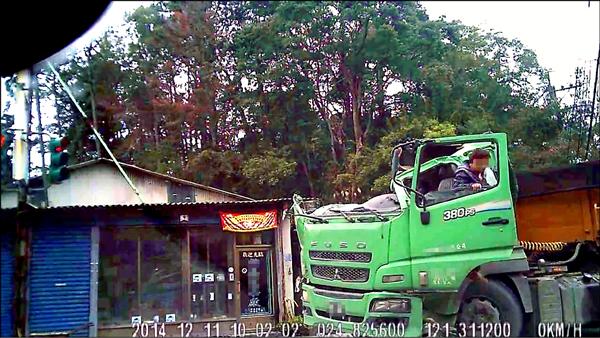 一輛砂石車為了閃避對向違規跨線行駛的小客車，結果撞上民宅屋頂，砂石車車頭的車頂瞬間被削掉一大半，撞上民宅後，楊姓駕駛還能自行下車。（取材自網路）