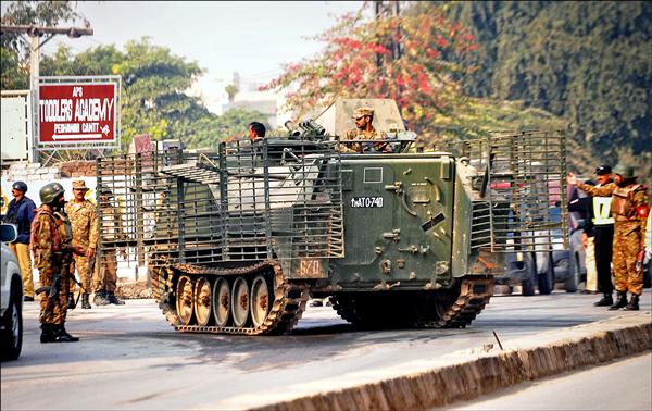 白夏瓦的陸軍公立學校攻擊案發生後，巴國軍方派出裝甲車在現場周邊警戒。（法新社）