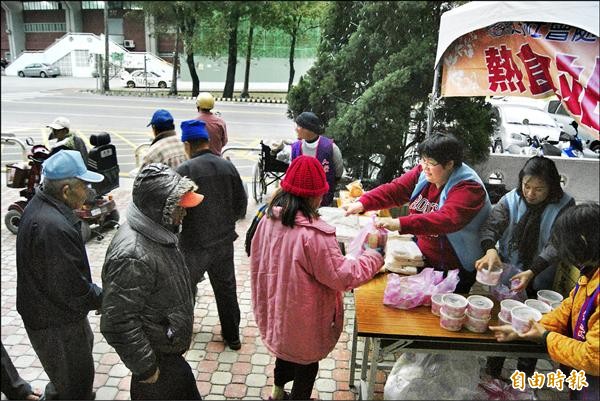 二、、三十名在台東市區的街友昨天下午到社會處開設的熱食站取雞湯、保暖物品。（記者王秀亭攝）