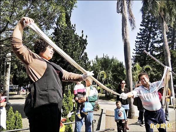 蔡阿財（右）、徐瑞基（左）夫婦，利用蔗糖合作拉出又長又脆的糖蔥。（記者蔡文居攝）