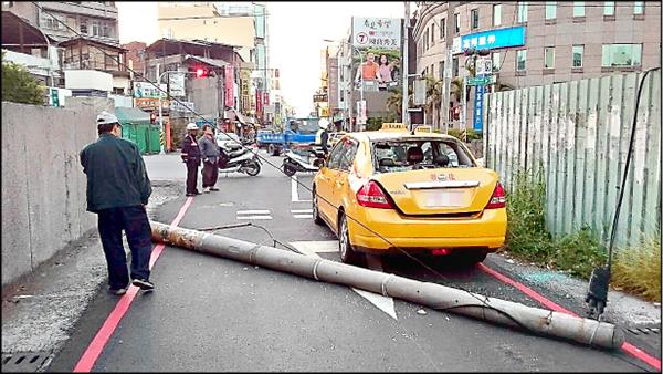 倒下的電線桿砸損計程車後車廂，玻璃碎裂。（記者張聰秋翻攝）