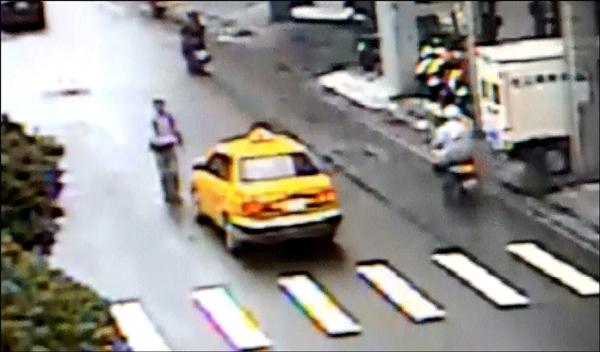 監視器拍下陳嫌行走在馬路中央，隨即攔下經過的汽機車攻擊過程。（記者曾健銘翻攝）