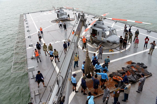 印尼海軍人員三日協助將已打撈起來的亞航QZ8501班機罹難者遺體吊掛放置到軍艦甲板上。搜尋人員三日已尋獲四大塊飛機殘骸。(路透) 印尼海軍人員三日協助將已打撈起來的亞航QZ8501班機罹難者遺體吊掛放置到軍艦甲板上。搜尋人員三日已尋獲四大塊飛機殘骸。(路透)