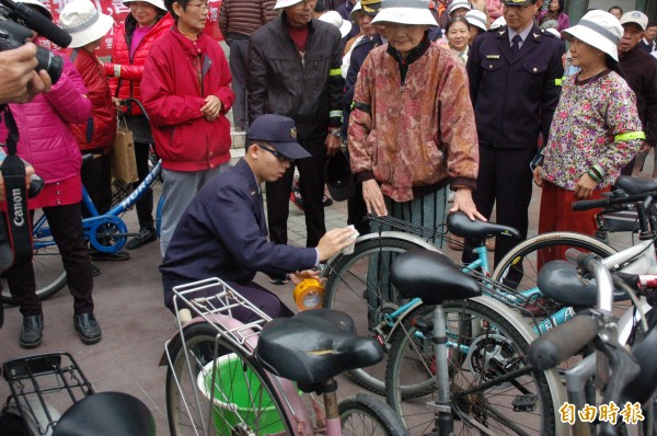 警察為長輩腳踏車張貼反光貼紙，提高安全保障。（記者林國賢攝）