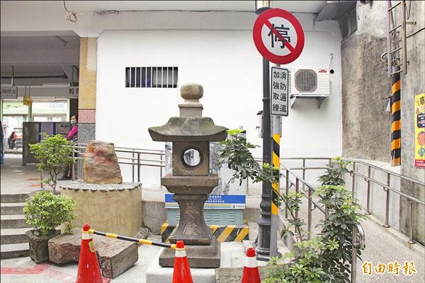 隱身瑞芳火車站魚池旁數十年的瑞芳神社石燈籠，現在被移到後站出入口展示。（記者林欣漢攝）