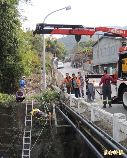 消防人員將跌落橋下的呂姓工人吊掛上路面送醫。（記者張勳騰攝）