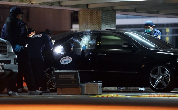 西門町峨嵋停車場13日發生槍擊案，兩名死者倒臥座車內，警方封鎖現場進行勘驗。（記者羅沛德攝）