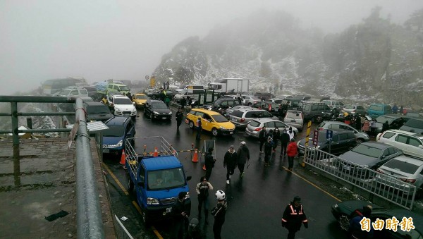 合歡山今天清晨5時許降雪，天亮後吸引大批遊客上山賞雪，（記者佟振國攝）