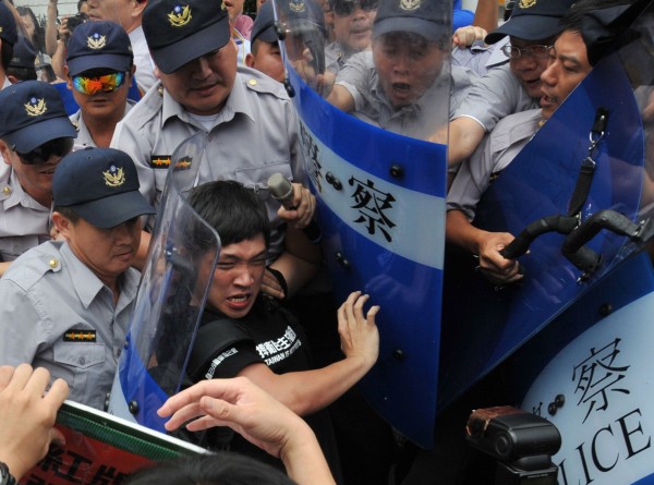 陳為廷因曾參與反黑箱服貿活動，涉嫌站在立法院圍牆外拉扯警察盾牌，遭台北地檢署依妨害公務罪起訴。圖為他在另一場抗議活動中與警方發生推擠。（資料照，法新社）